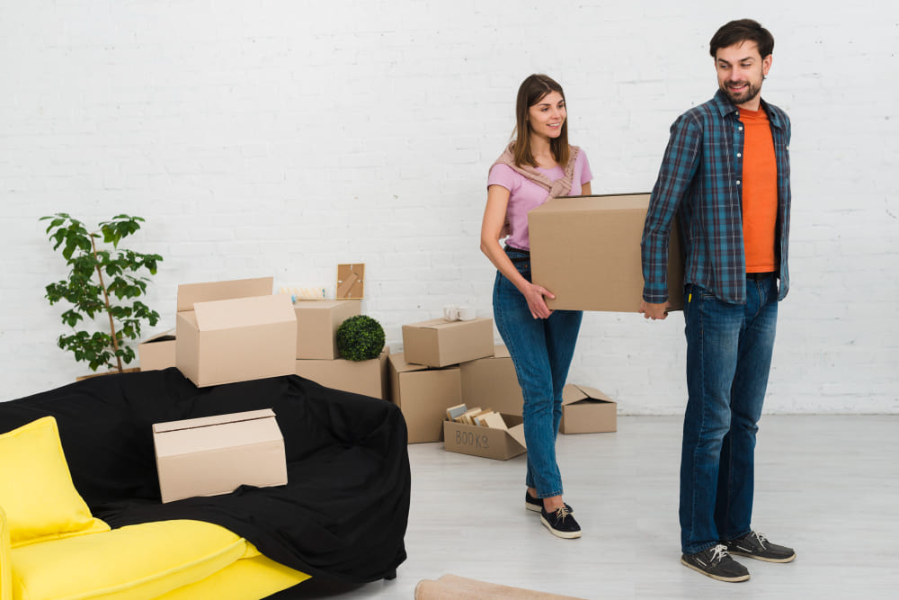Couple organizing belongings during house move Couple organizing belongings during house move
