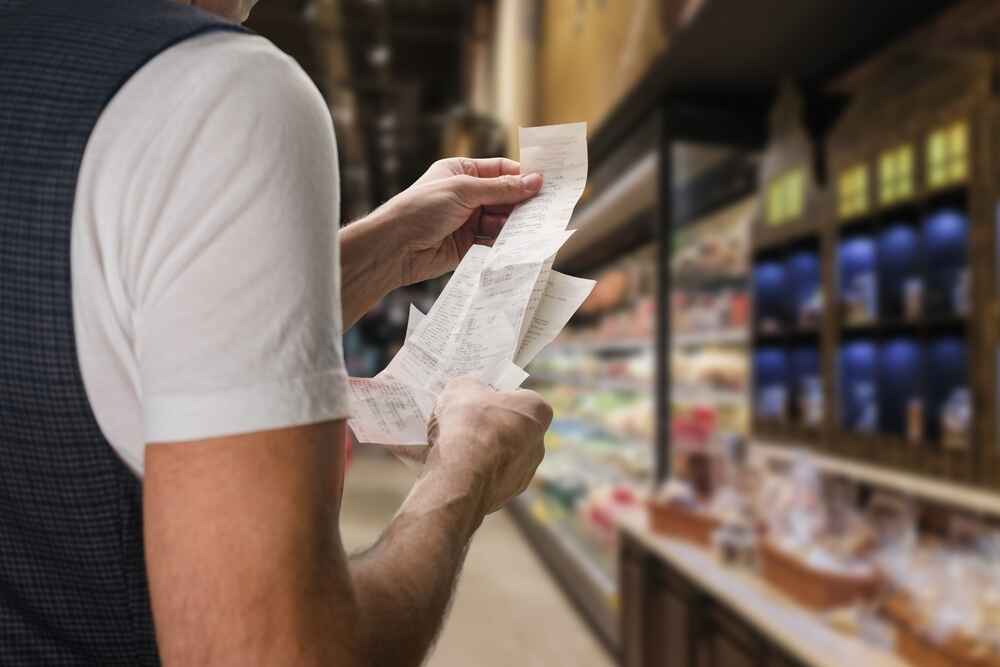 A Man Looking At His Grocery Bill In Hobart